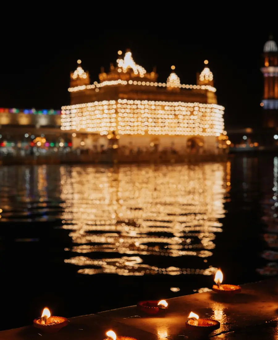 Harmandir Sahib (the Golden Temple) in Amritsar lit at night, with diyas along the walkway